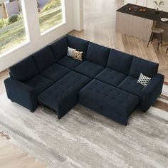 a living room with a large blue sectional couch in the middle of it and a rug on the floor