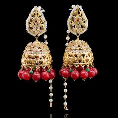 A must-have classic piece to complement your festivities! The look includes necklace, a pair of earrings and a nose ring. This divine set features CZ stones in combination with dangling ruby beads paired with matching earrings and a stunning nose ring designed with kundan stones and pearl moti. Gold-plated on high-quality brass as base metal. Made by order. Kindly allow 5-7 weeks for the delivery of this item. For custom or urgent requests, please contact support@alacouture.com. *Please Note: We Traditional Ruby Bridal Earrings For Party, Ruby Meenakari Jhumkas For Festivals, Bollywood Style Ruby Chandbali Jhumkas, Red Ruby Danglers For Wedding, Traditional Ruby Jhumkas With Tilla, Ruby Meenakari Jhumkas Temple Jewelry, Heavy Ruby Jhumkas For Festive Occasions, Ruby Meenakari Temple Jewelry Jhumkas, Heavy Ruby Traditional Jhumkas