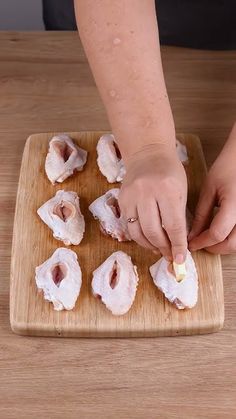 a person is cutting up some food on a wooden board