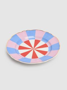 a pink and blue plate with a large red and white striped design on the rim