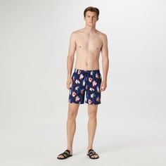 The Cosmo swim trunks are crafted from premium comfort stretch polyester in a floral print and feature an elastic waist with adjustable drawstring, a breathable stretch mesh lining, drainage grommets, side pockets, a rear patch flap pocket, UV protection and quick-dry technology. The sleek 17.5-inch out seam, offers the perfect balance between coverage and freedom of movement, making it an ideal choice for the beach or relaxing by the pool. Navy Swim Trunks With Pockets For Summer, Navy Swimwear With Pockets For Summer, Navy Nylon Swimwear For Summer, Casual Navy Swim Trunks For Pool, Casual Navy Swimwear For The Pool, Navy Swim Trunks For Vacation, Navy Swim Trunks For Vacation Beachwear, Printed Swimwear For Pool, Printed Short Length Swimwear For Pool