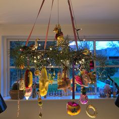 a chandelier hanging from the ceiling in front of a window filled with christmas decorations