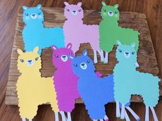 colorful llamas cut out from paper on a wooden board