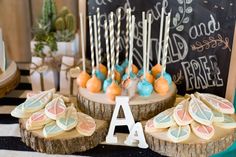 desserts are displayed on wooden slices and stand next to a chalkboard sign with the letter a