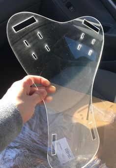 a person holding up a car windshield shield