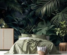 a bed with green sheets and pillows in front of a large wall mural that has palm leaves on it