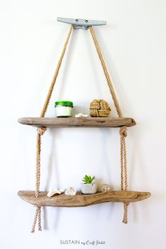 two wooden shelves with rope hanging from the top and one shelf holding potted plants