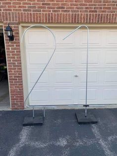 a pair of black square stands in front of a garage door with a heart shaped wire attached to it