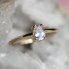 Moonstone is known as a stone of protection and is associated with the crown and third eye chakras.  Bring the moonstone's protective energy into your life with our 14K "Chakra" ring!  Handcrafted from 14K gold and featuring a pear-shaped rainbow blue moonstone in a bezel setting.  - Rainbow blue moonstone measures 6mm by 4mm, very high VS quality, picks up colors of pink, yellow, blue, and purple   - Choose between soldi 10K or 14K gold - Round band measures 1.3mm in width Processing Times -  C White Moonstone Celestial Ring In 14k Gold, White Celestial Moonstone Ring In 14k Gold, Celestial White Moonstone Ring As Birthstone, Celestial White Moonstone Birthstone Ring, Celestial Style White Moonstone Birthstone Ring, Celestial White Moonstone Ring With Halo, Celestial Style White Moonstone Ring With Halo, Spiritual Moonstone Teardrop Ring, Spiritual Teardrop Moonstone Ring