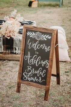 a chalkboard sign that says welcome to the bride and groom at an outdoor wedding