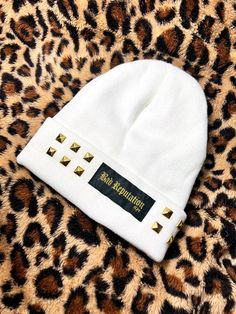 Super warm and comfy white knit beanie. Features a gold Bad Reputation logo patch, and rows of gold studs.  Keep warm, stay glam. One size. White Hat For Fall Streetwear, White Streetwear Hat For Fall, Trendy Fitted White Beanie, White Fall Streetwear Hat, White Beanie For Winter Streetwear, White Beanie For Streetwear, Gold Bad, Steve Miller Band, White Beanie