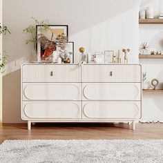 a white dresser sitting on top of a hard wood floor next to a wooden shelf