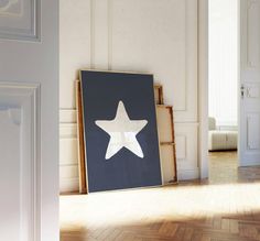 an empty room with a large white star on the wall next to a framed photograph