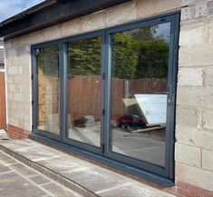 an outside view of a house with glass doors and windows on the side of it