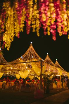 an outdoor event with many lights and decorations on the ceiling, all lit up at night