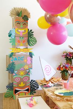 a birthday party with balloons and decorations on the table, including an assortment of paper cutouts