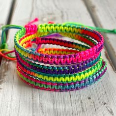 multicolored bracelets are sitting on a wooden table