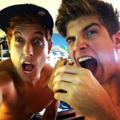 two young men are eating food together