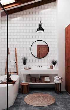 a bathroom with a round mirror above the bathtub and rug on the floor next to it