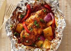 chicken, potatoes and peppers in foil on a table