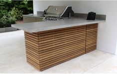 an outdoor kitchen with a grill and counter top