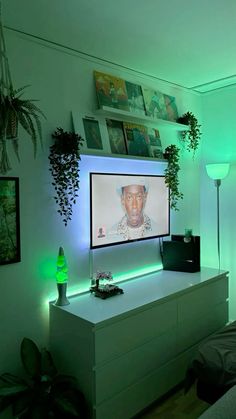 a bedroom with a flat screen tv on the wall and plants in the corner next to it