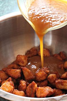 the sauce is being poured over the food in the bowl to make it look like fried chicken