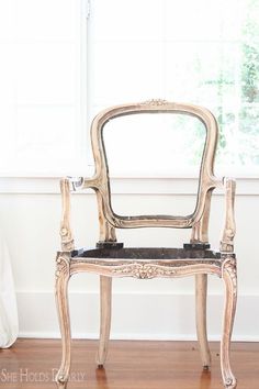 an old chair sitting in front of a window