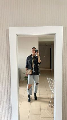 a man is taking a selfie in the mirror with his cell phone while wearing ripped jeans