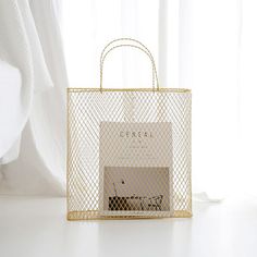 a white shopping bag sitting on top of a table next to a curtained window