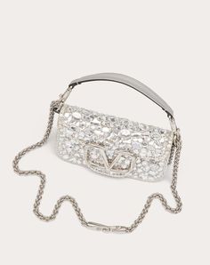 Valentino Garavani Locò small shoulder bag covered in crystals with metallic VLogo Signature detail. Equipped with both a detachable sliding chain strap and a detachable handle, this accessory can be worn as a crossbody/shoulder bag or carried as a handbag. - Palladium-finish hardware - Magnetic closure with logo - Removable leather handle - Shoulder strap with removable sliding chain - Nappa leather lining. Interior: one slip pocket Shoulder strap drop length: 55 cm / 21.6 in. - Dimensions: W20 Bow Mules, Studded Sneakers, Oxford Boots, Belt Jewelry, Bag Cover, Small Shoulder Bag, Boots For Sale, Small Leather Goods, Nappa Leather