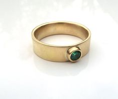 Lovely rich 18ctrecycled  yellow gold with a 3.5mm round emerald. Emeralds are the birthstones for May.This is a good quality stone with great colour and sparkle.The band is 5mm wide with a slight curve on the inside for a comfort fit.the ring is made to order in your size. I can also make it with diamonds or sapphires or a stone of your choice. Also available in white gold, platinum and silver.for other emerald  rings go to www.etsy.com/shop.karenjohnsondesignor Facebook.com/karenjohnsondesignO 14k Yellow Gold Emerald Ring With Tension Setting, Modern Gold Emerald Ring, Gold Emerald Ring With Round Stone, Yellow Gold Emerald Ring With Tension Setting As Gift, Gold Emerald Solitaire Ring With Round Band, Gold Solitaire Emerald Ring With Round Band, Gold Emerald Ring With Tension Setting For Promise, Modern Yellow Gold Emerald Ring With Tension Setting, Gold Emerald Ring With Birthstone - Round Band