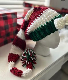 a crocheted christmas hat and scarf on a mannequin's head