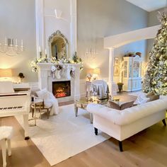 a living room filled with furniture and a christmas tree in front of a fire place