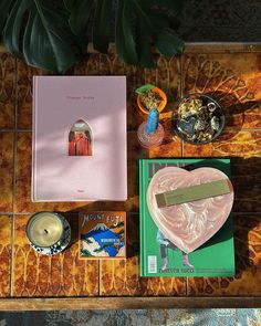 an assortment of books and candles on a table