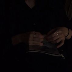 a woman in black shirt holding a book with her hands and ring on the cover