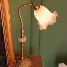 a lamp that is sitting on top of a table in front of a framed photo