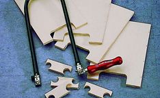 several pieces of wood are laid out on the floor with tools to make them look like puzzles