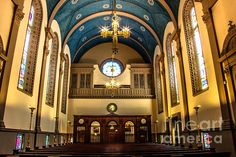 the inside of a church with pews and stained glass windows