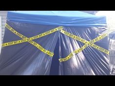 a blue tent with yellow tape wrapped around it