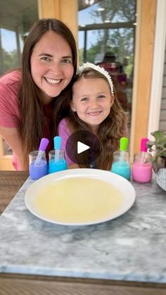 a mother and daughter are smiling in front of a table with soaps on it