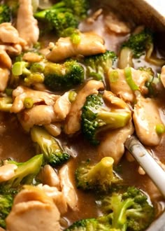 chicken and broccoli in a sauce with a spoon