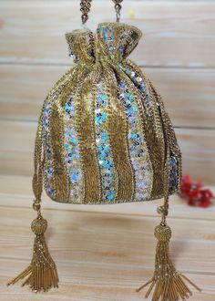 Indian Golden color Women Fashion Handmade Potli Bag with hard base, Ethnic Wedding And Festivals, hand bag, Bridal Bag Embellished With Beads & Pearls Potli Bag  Dimensions: Length: 9.0 inches Width: 7.0 inches Depth: 8.5 inches This Handmade Beaded potli bag with hard base is good match for beautiful Women with both Indian wedding and Festivals.  The bag is embellished with high quality semi-precious stones like pearls, beads, crystals, sequins on a beautiful high quality fabrics. Two drawstrings at both ends give our Potly bag a stunning look. Wrist handle studded with beads.  This Hand Pouch would be best complement to your designer saree, lehanga or any other kind of Western Wear dress. The ideal gifts for your daughters, mothers, grandmothers, colleagues, partners, students, and girl Festive Bag With Mirror Work For Festivals, Traditional Embellished Shoulder Bag For Celebrations, Festive Beaded Shoulder Bag For Wedding, Festive Mirror Work Shoulder Bag As Gift, Festival Evening Bag With Handwork For Celebrations, Gold Bags With Mirror Work For Gifts, Traditional Embellished Bags For Celebration, Festive Evening Bag With Handwork For Celebrations, Elegant Celebration Potli Bag With Mirror Work