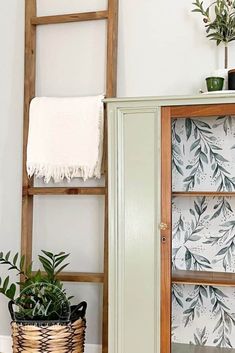 a bathroom with a wooden ladder next to a green cabinet