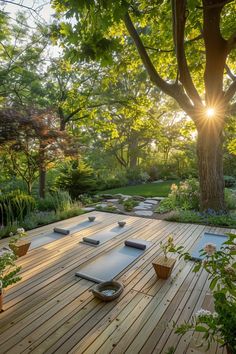 the sun shines brightly through the trees in this garden with yoga mats on it