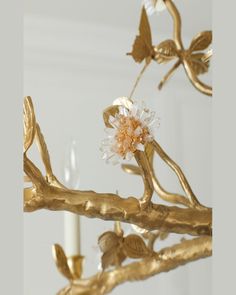 a close up of a gold branch with flowers and leaves hanging from it's center