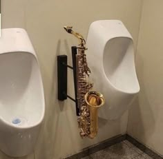 two urinals and a saxophone on the wall