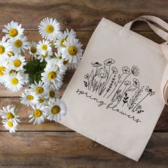 Welcome spring with this attractive yet functional canvas tote bag. Featuring some beautiful wildflowers with the phrase "Spring Flowers" in an eye-catching script font, this sustainable tote bag would make the perfect birthday or Mother's Day gift.   This 100% cotton bag comes in one size - 15" x 16"- perfect for everyday use. The heavy canvas fabric is durable and will last for years. This functional bag features 20" canvas handles, allowing you to carry lots of flowers or farmer's market trea Spring Canvas Gift Bag For Everyday Use, White Botanical Style Bag For Spring, Spring Canvas Tote Bag For Gift, Spring Gift Canvas Tote Bag, Spring Botanical Rectangular Bags, Everyday Spring Canvas Bag With Letter Print, Spring Canvas Gift Bag, Botanical Style Bags For Spring Gift, Botanical Style Bags For Spring