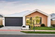 a house with a palm tree in front of it and two garages on the other side