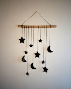 a wind chime with stars and crescents hanging from it's side against a white wall